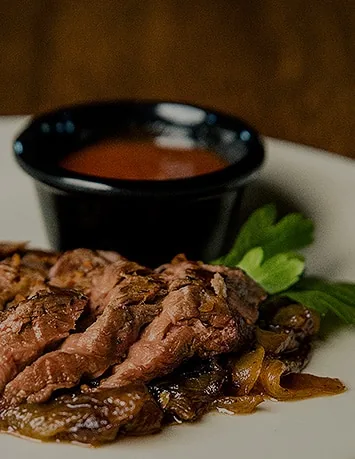 Sliced wild game appetizer with dipping sauce