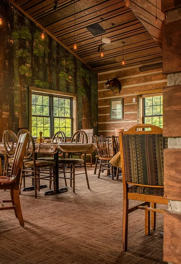 Dining area with tall windows onto the woods