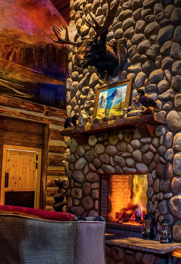 Stone fireplace and mounted elk in the lodge lounge