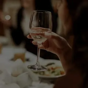 A guest raising a glass at a reception table